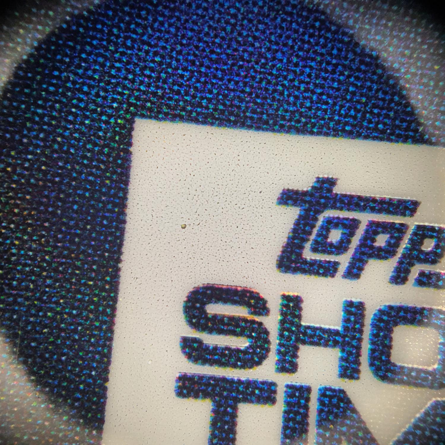 Macro du repère A : tramage du logo et grain du papier